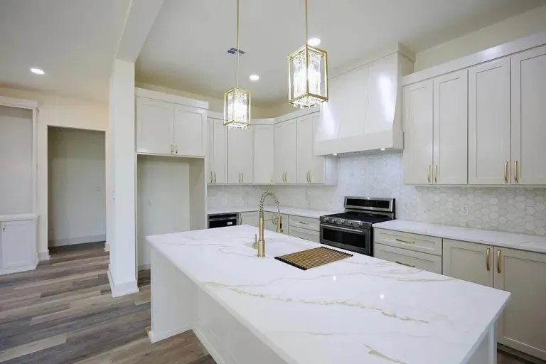 Custom kitchen with marble island and statement brass pendants