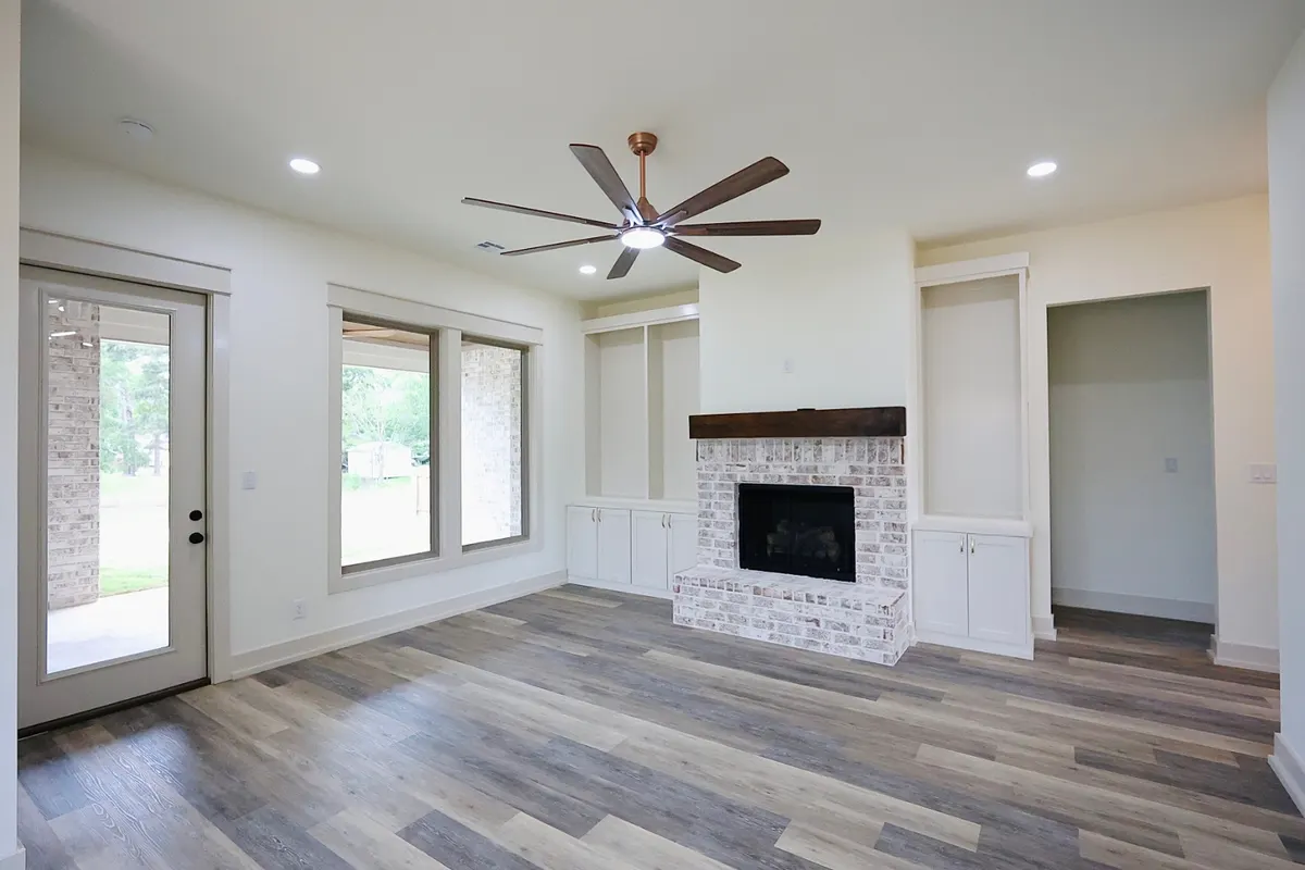 Living room with whitewashed brick fireplace and custom built-ins